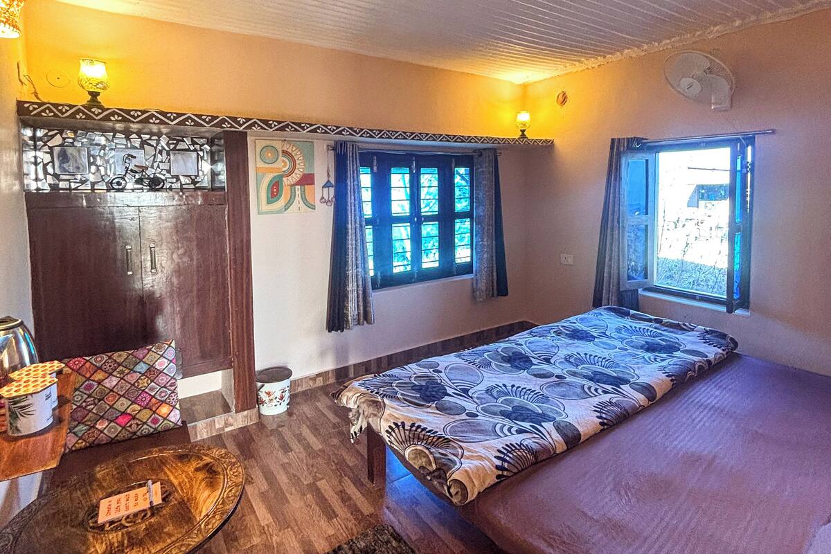 A room with a bed, a desk, a chair, a window, and a door.
