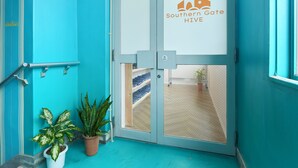 Una puerta color turquesa con un panel de vidrio que muestra el logotipo 'Southern Gate Hive'.