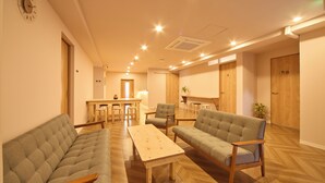 Un amplio salón con sofá, sillones, una mesa de centro y una mesa de comedor.