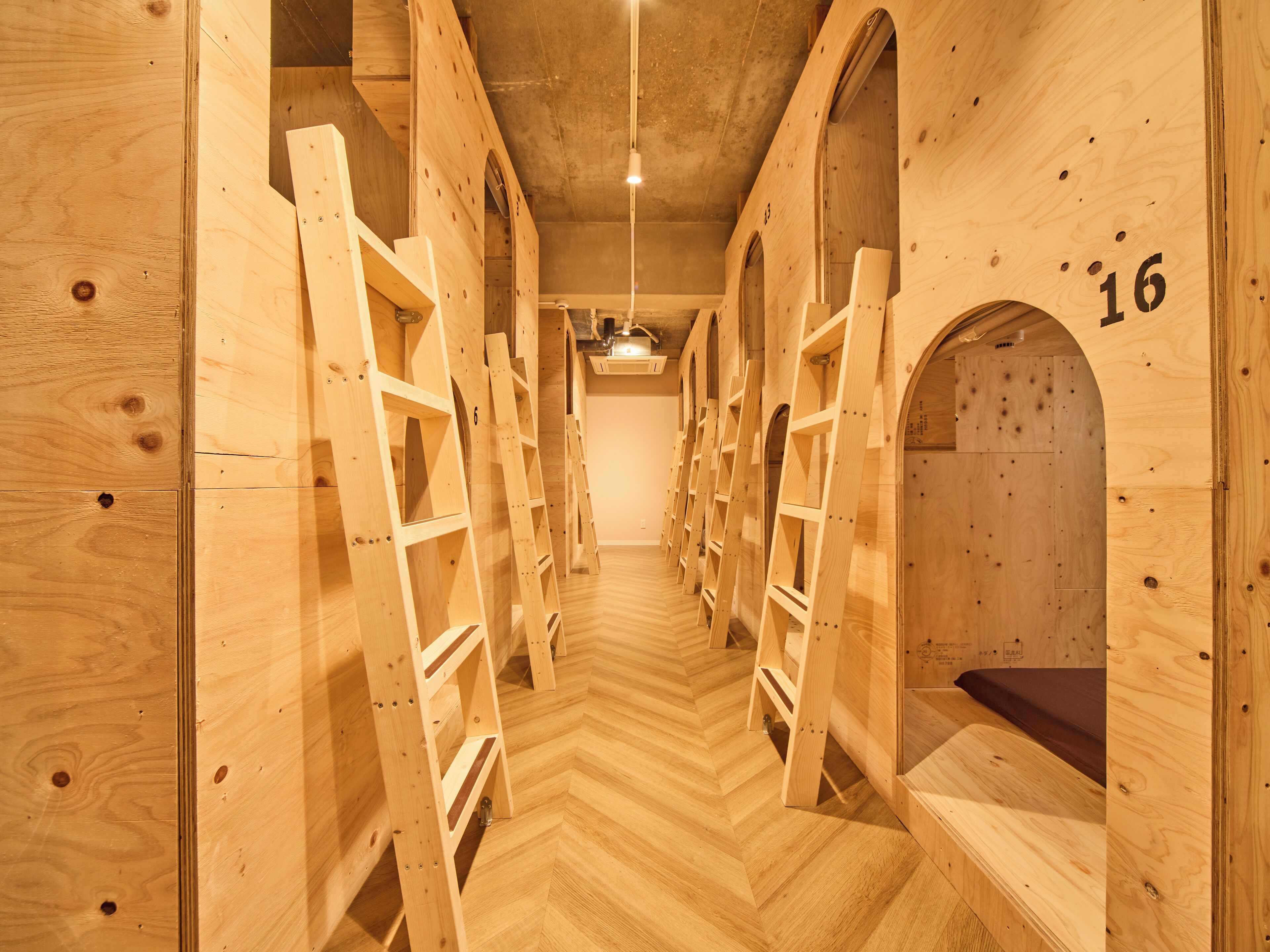 A wooden interior with bunk beds and a herringbone floor pattern.