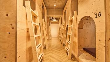 A wooden interior with bunk beds and a herringbone floor pattern.