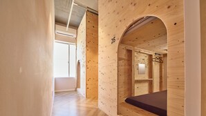 Un interior de madera con una litera, un ventanal pequeño y una puerta.