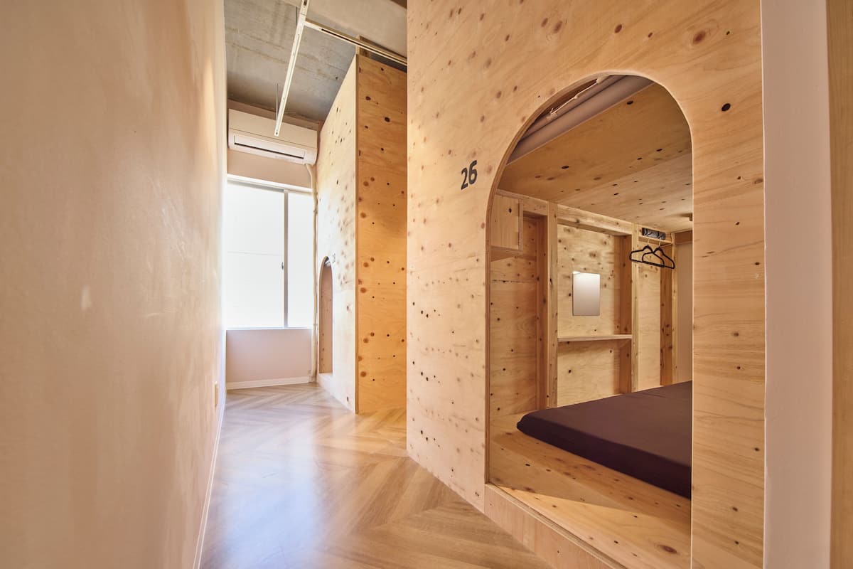 Un intérieur en bois avec un lit superposé, une petite fenêtre et une porte.