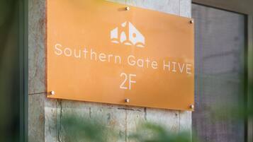 Une enseigne indiquant « Southern Gate Hive 2F » est fixée sur la façade d’un immeuble.