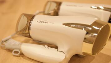 A white hairdryer with a metallic nozzle and a cord.