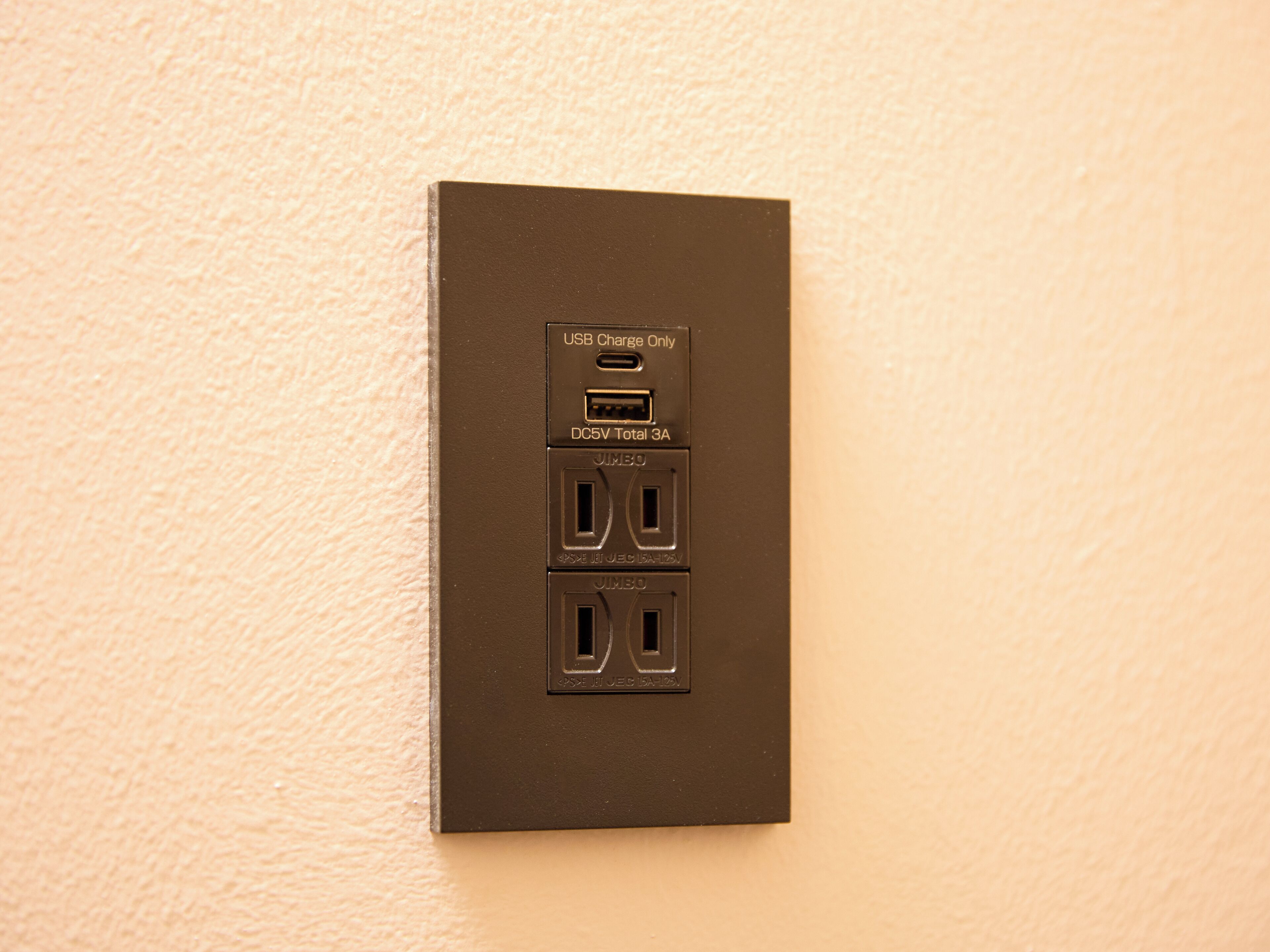 A wall-mounted electrical outlet with USB charging ports and two standard outlets.