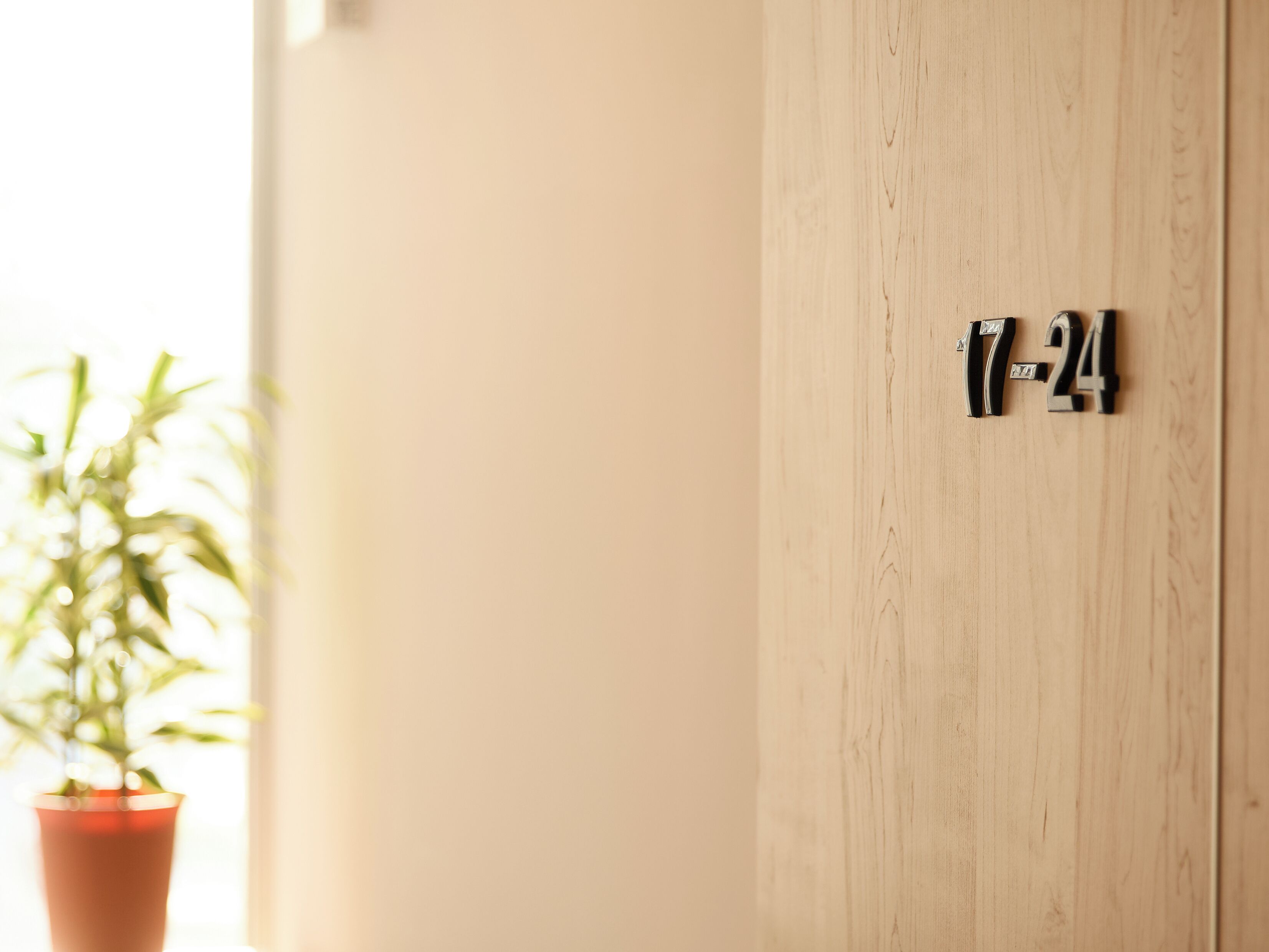 A wooden door with a number plaque reading "17-24".