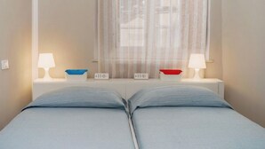 Ein Doppelbett mit zwei Nachttischen, jeweils mit einer Lampe und einer kleinen Schale.