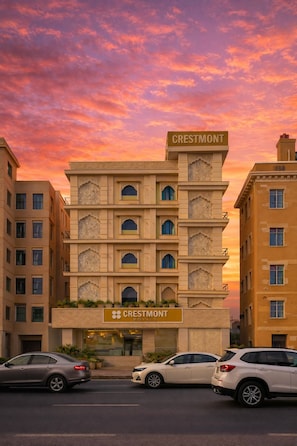 A multi-story hotel with a prominent Crestmont sign, featuring a traditional architectural style with intricate facade details.