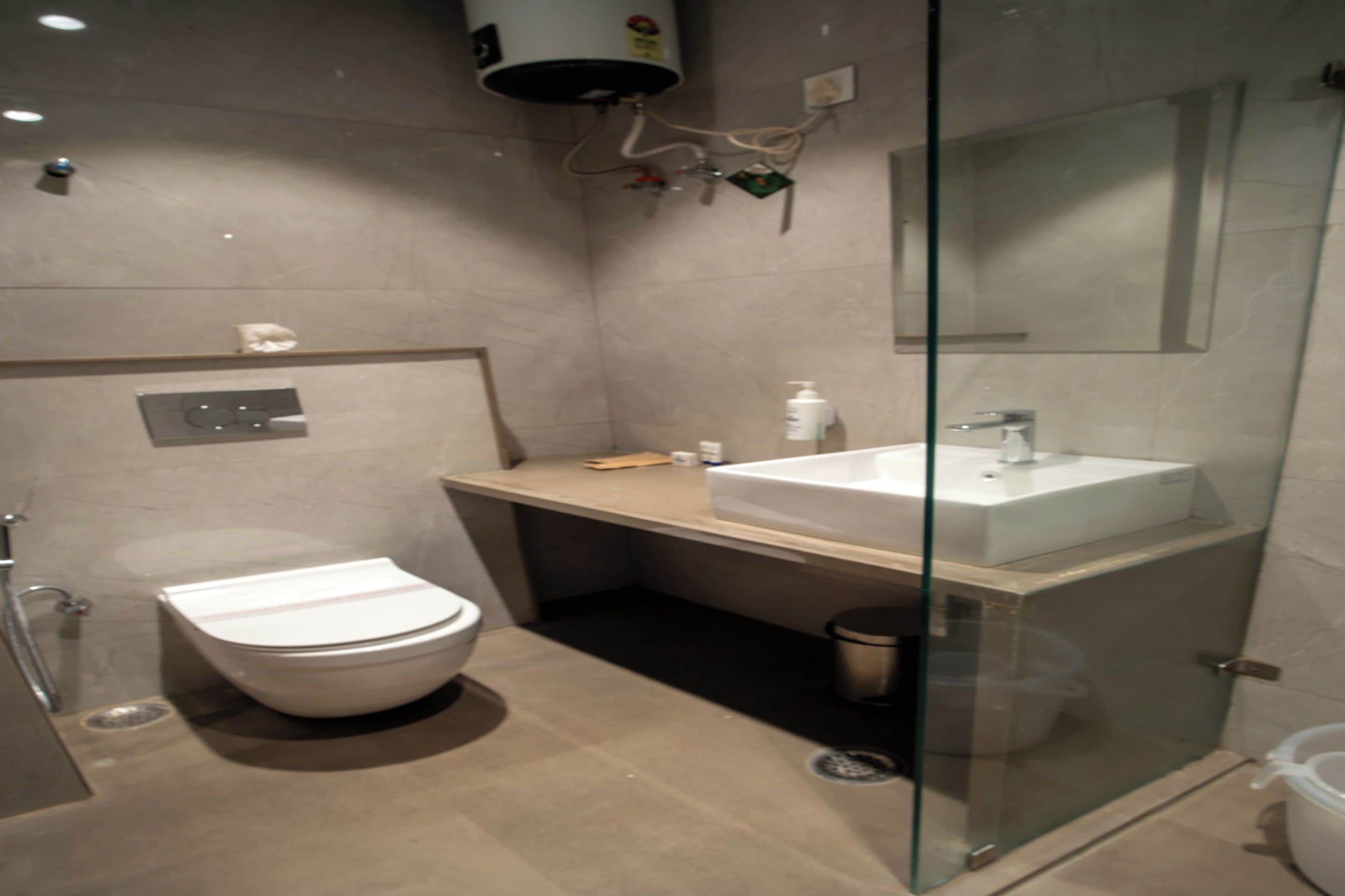 A modern bathroom with a toilet, sink, and glass shower enclosure.