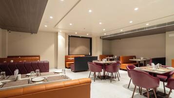 Un espace repas moderne avec des banquettes et des tables en cuir, équipé du nécessaire de base pour le service à table.