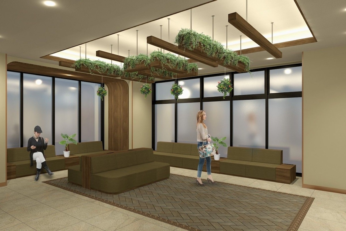 A modern lobby with seating areas, wooden beams, and hanging planters.