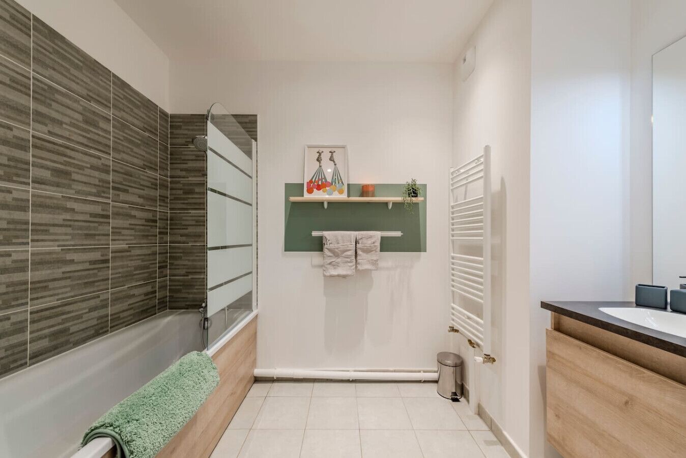 A modern bathroom with a shower, a toilet, a sink, and a towel rack.