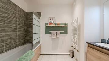 A modern bathroom with a shower, a toilet, a sink, and a towel rack.