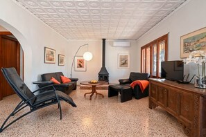 A living room with a fireplace, seating, a television, and artwork on the walls. - Finca La Solana – Holiday home with a private pool (Jalón)