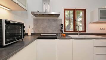 Een magnetron, een oven, een kookplaat, een vaatwasser