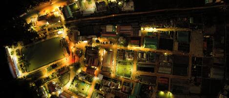 An aerial view of a densely packed urban area with illuminated buildings and streets at night.