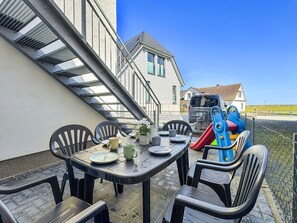 A patio with a table set for dining, chairs, and children's play equipment. - 5220 - Küstenfeuer - Coastal Lighthouse - 5220 - Luxury - 3 bedrooms - in Dahme with ocean views (Dahme)