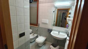 Ein kleines Badezimmer mit Toilette, Bidet und Waschbecken.