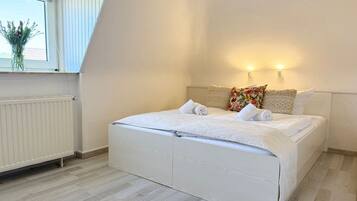 Un dormitorio con cama, ventana y radiador.