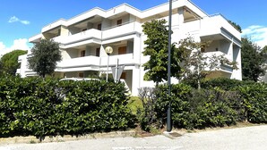 Un edificio residenziale a più piani con balconi, immerso nel verde.