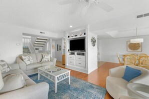 A modern living room with a sofa, coffee table, and TV stand. - 3 Bedroom 3 Bath Golf and Beach Getaway (Pawleys Island)