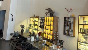 A modern bar area with a long counter, multiple stools, and shelves with various items. - Zhangjiajie YunYe Hotel (Zhangjiajie)