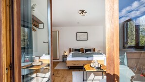 A bedroom with a bed, bedside table, and a view through a glass door. - Apartment 'Fewo Am Steinbach - Stoaboch' with Mountain View, Balcony and Wi-Fi (Reit im Winkl)