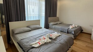 Ein Hotelzimmer mit zwei Betten, einem Deckenventilator und einem Vorhangfenster.