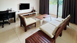 Ein modernes Wohnzimmer mit Fernseher, Couch, Couchtisch und Deckenventilator.