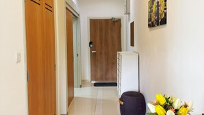 Ein Korridor mit Holztüren, einem weißen Schrank und einem Tisch mit Blumen.