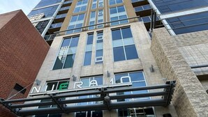 Ein hoch aufragendes Gebäude mit modernem Design, das eine auffällige 'NUE'-Beschriftung an der Fassade trägt.