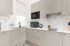 Fridge, stovetop, dishwasher, coffee/tea maker