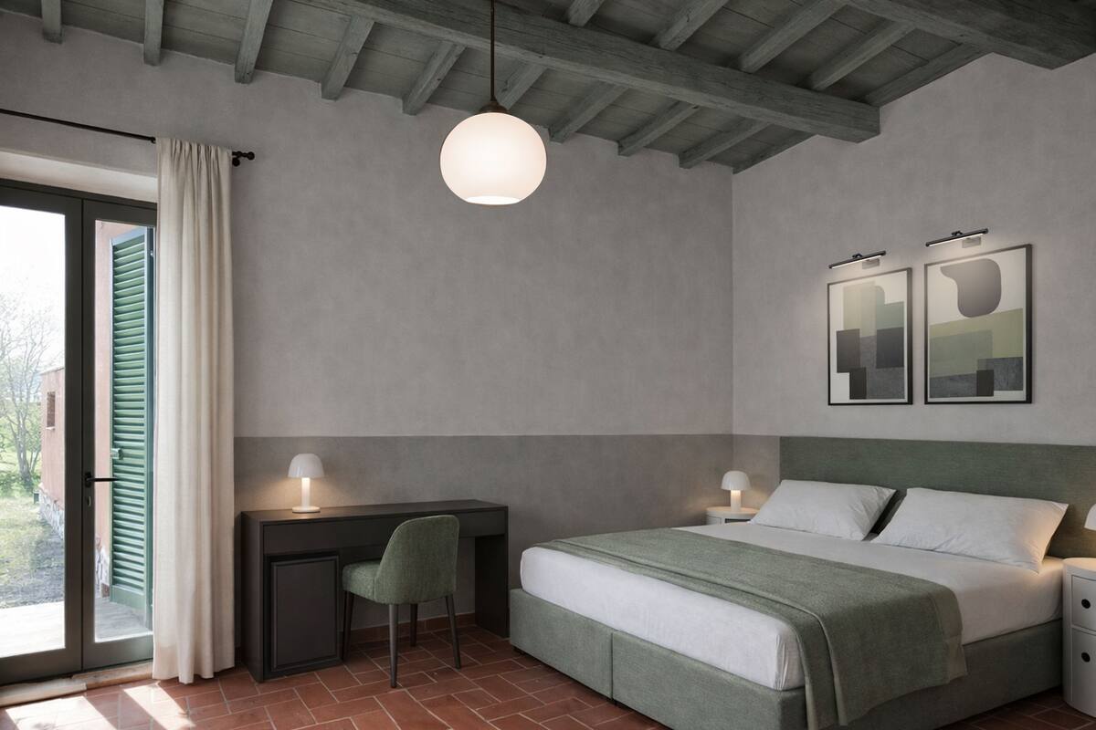 A bedroom with a bed, desk, chair, and two bedside tables.