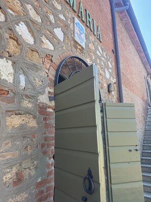 A stone building with a metal gate and a sign that reads 'MARIA.' - Pian di Barca (Grosseto)