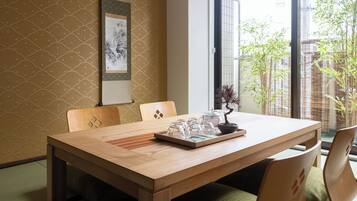 A dining area with a wooden table, chairs, and a bonsai plant.