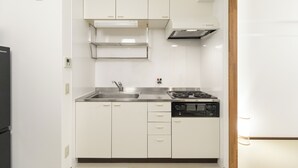A modern kitchen with white cabinets, a stainless steel sink, and a built-in microwave. - OPEN Sale! Walking distance from Umeda area / Easy access to Namba and Dotonbori / 10 minutes to USJ by train / Max. 8 people (Kita-ku, Osaka-shi)