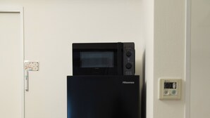 A black Hisense refrigerator in a kitchen with light wooden flooring and white walls. - OPEN Sale! Walking distance from Umeda area / Easy access to Namba and Dotonbori / 10 minutes to USJ by train / Max. 8 people (Kita-ku, Osaka-shi)
