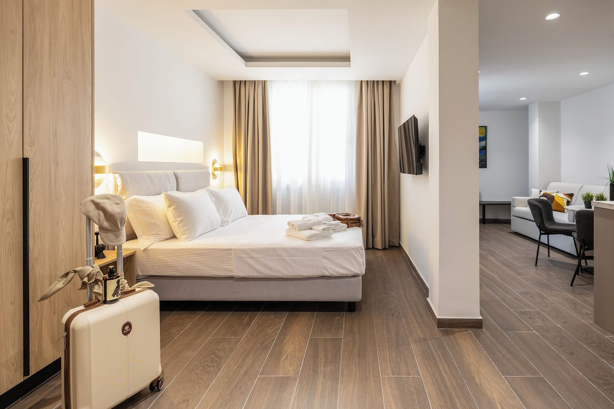 A modern hotel room with a large bed, a desk, and a chair.