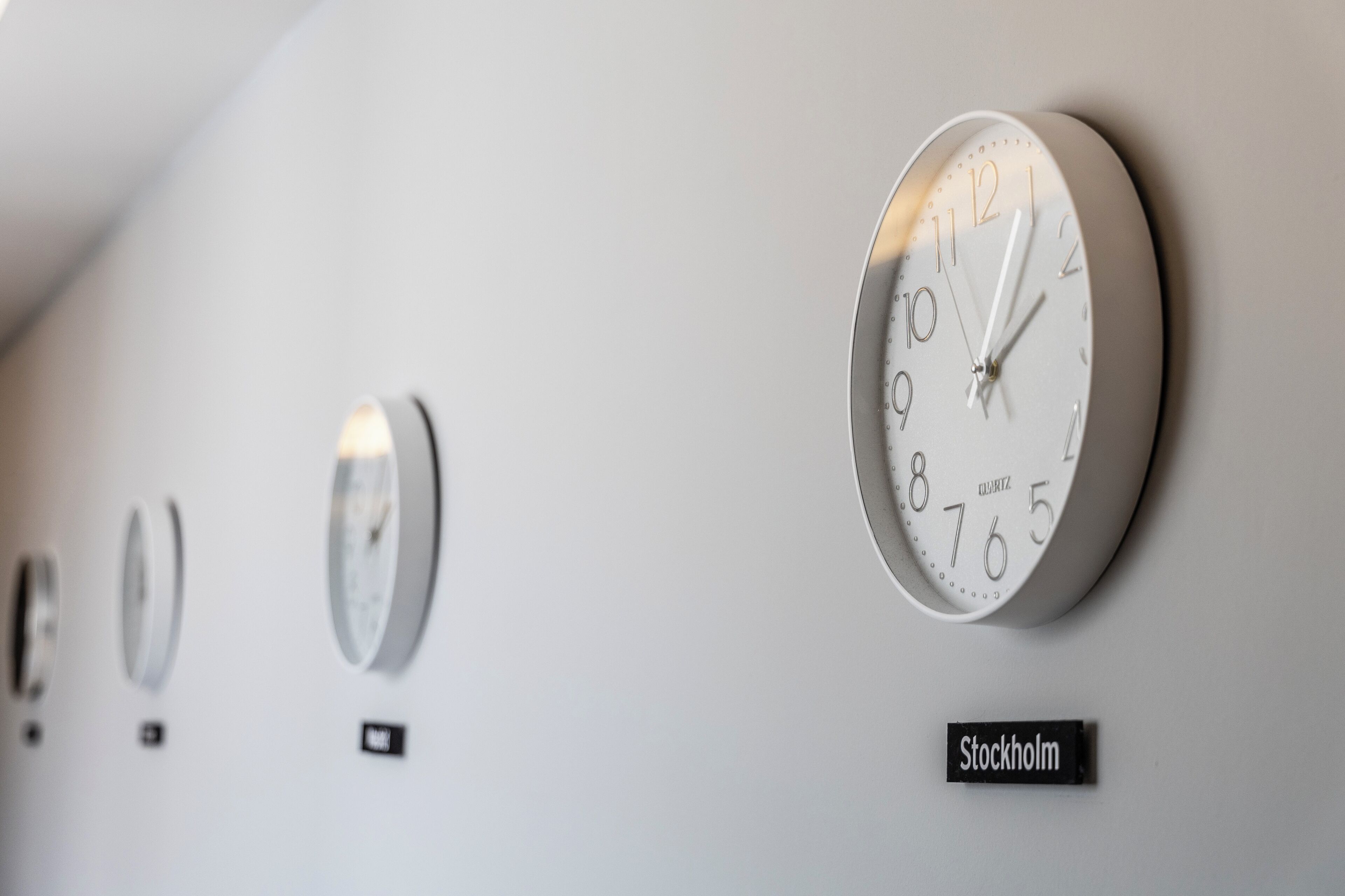 Een muur met drie klokken en een bord waarop 'Stockholm' staat.