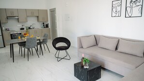 Een moderne keuken met een zithoek, een bank en twee abstracte kunstwerken aan de muur.
