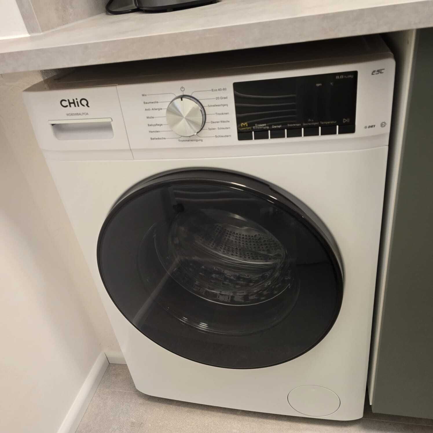 A front view of a CHiQ washing machine with a control panel and a transparent door.