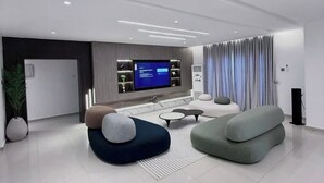 A modern living room with a flat-screen TV, comfortable seating, and a large window with curtains. - Nextdoor Apartment (Kaduna)