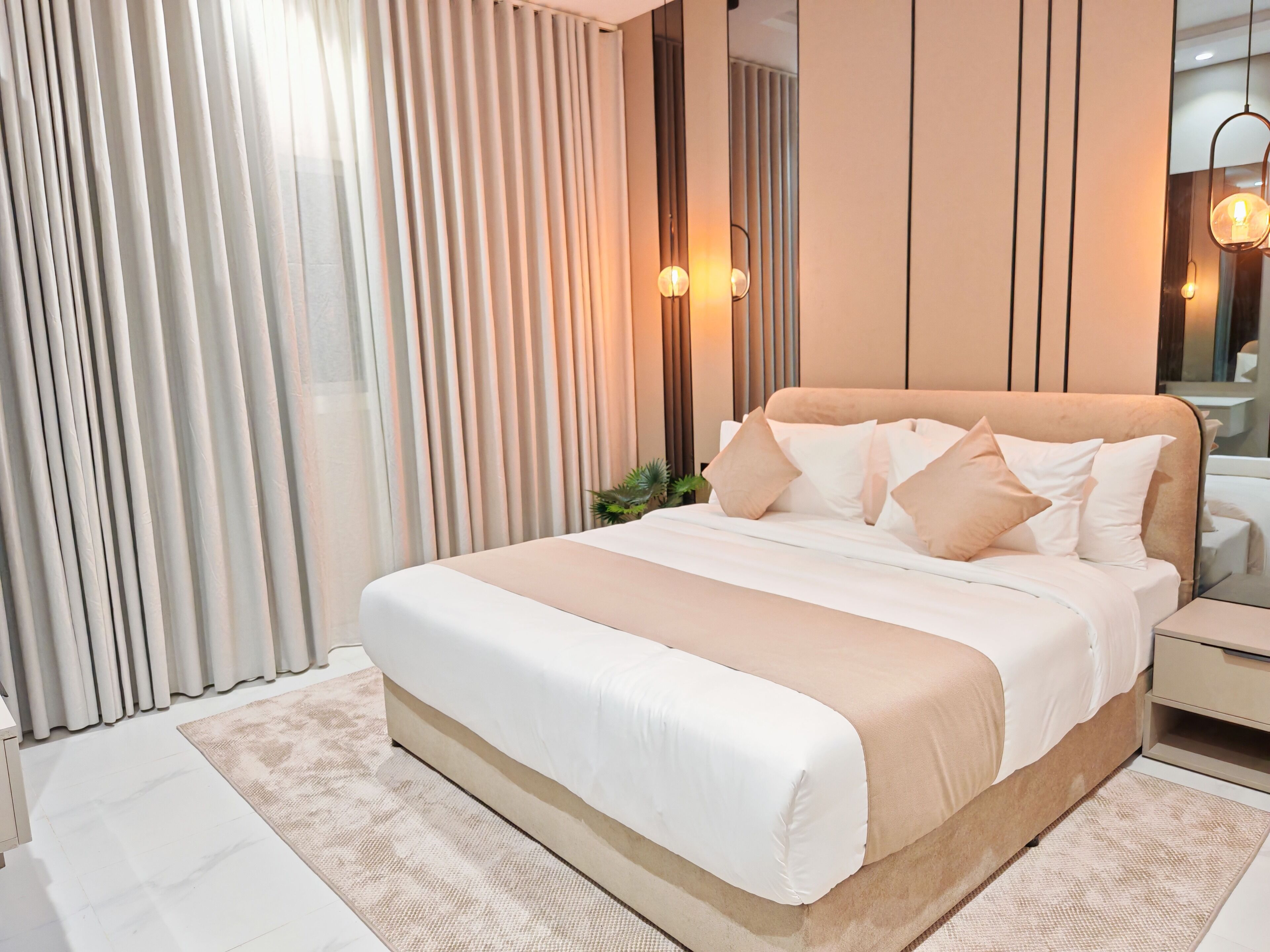 Un dormitorio moderno con una cama grande, una mesita de noche y un espejo.