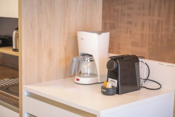 A coffee machine and a glass carafe on a white countertop in a kitchen area. - Feelgood Studioapartment in Graz-sued 24-7 Self Check IN (Graz)