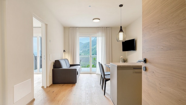 Een moderne woonkamer met een bank, eethoek en keukenbar.
