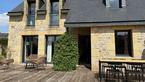 A stone house with a wooden deck, two windows, and a door. - KERALORH - Holiday home for rent in La Trinité sur Mer  - S1 (La Trinité-sur-Mer)