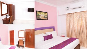 A hotel room with a bed, a desk with a chair, a wardrobe, a television, and an air conditioning unit. - SBK Park Inn (Kanchipuram)
