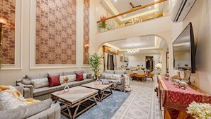 A spacious living area with a high ceiling, a dining area, and a kitchen. - Heaven in Hills By ELIVAAS with pvt pool (Māvli)