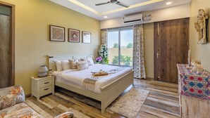 A bedroom with a bed, bedside table, and a window with curtains. - Heaven in Hills By ELIVAAS with pvt pool (Māvli)